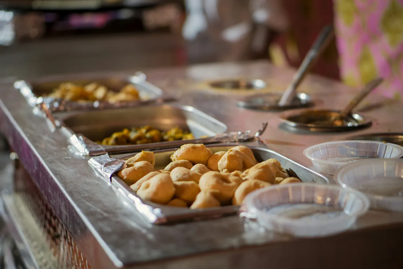 A buffet table with trays of savory snacks and serving utensils